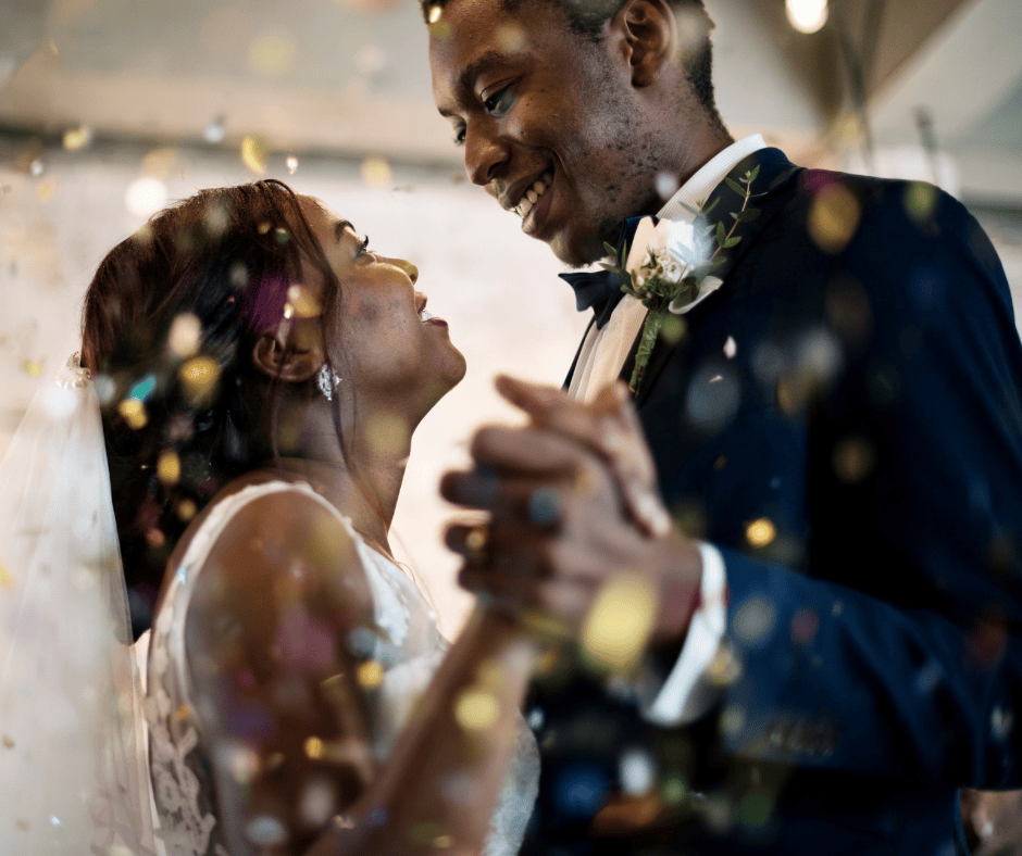 Newlywed couple smiling at each other while dancing