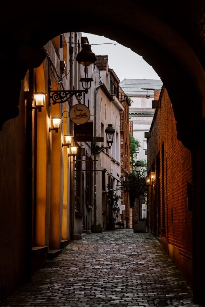 Brüssel - Gasse am Abend. Links leuchten 4 Lampen an einem Haus.