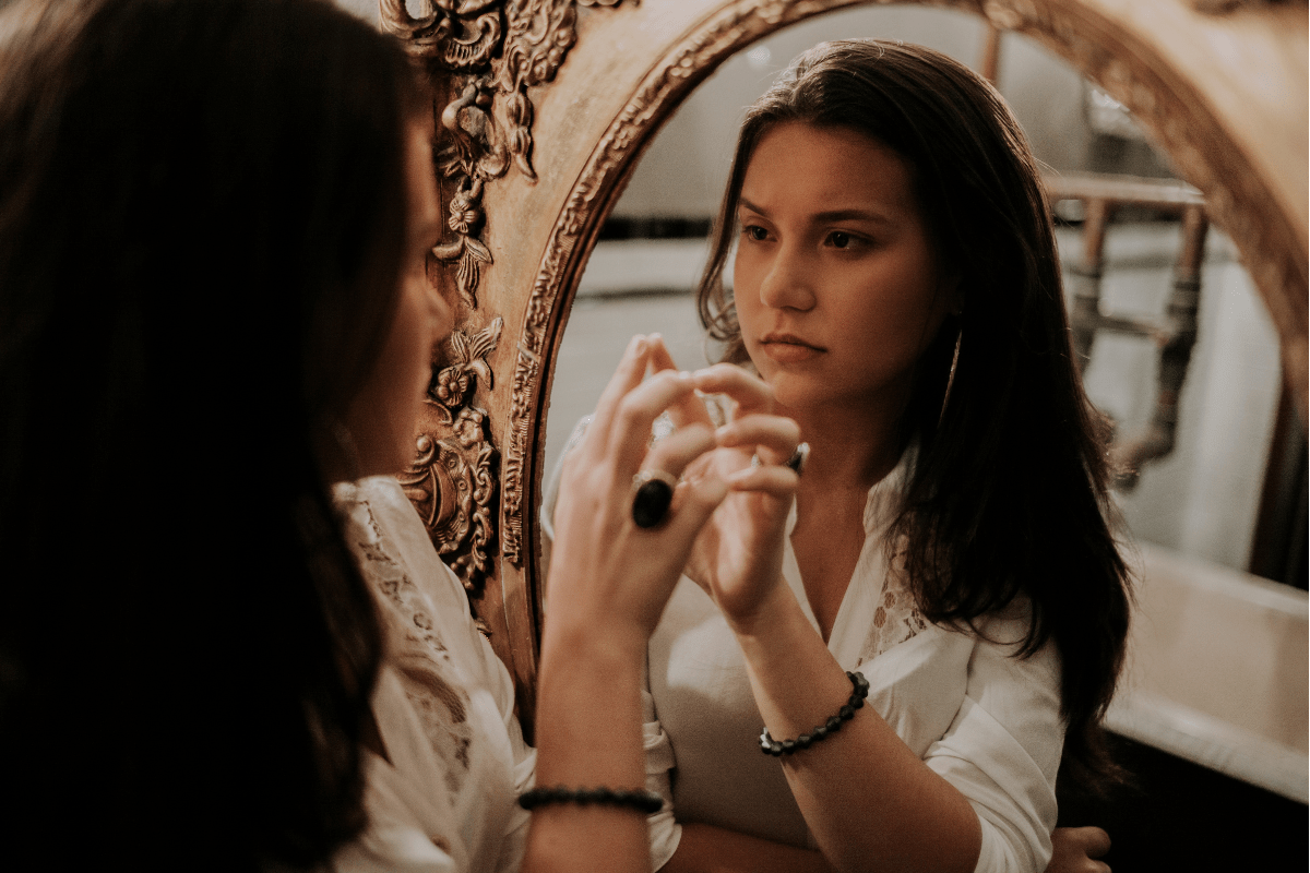 woman looking at her image in a mirror, time for self reflection