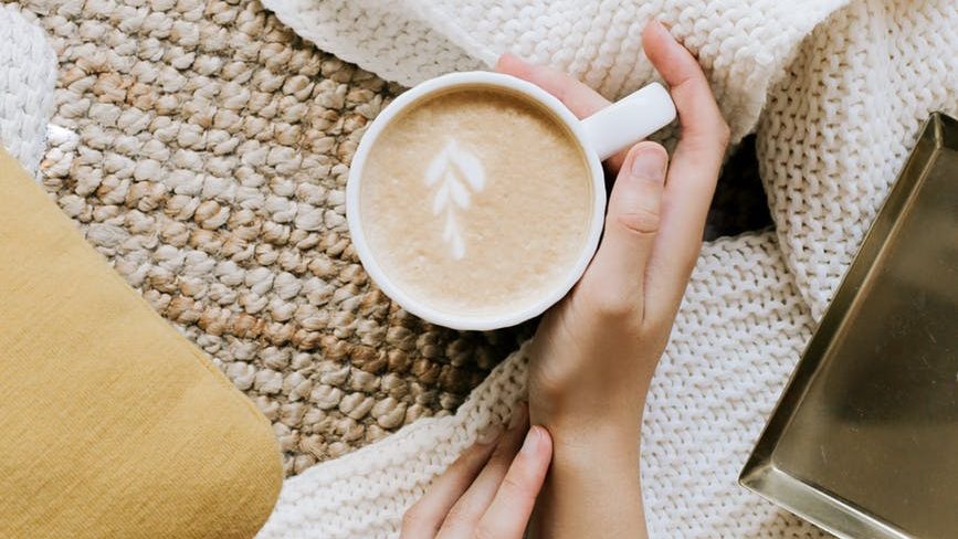 crop anonymous woman with cup of hot cappuccino
