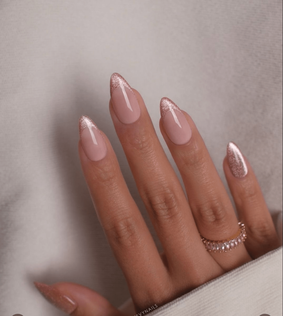 Soft pink French tip nails with a rose-shimmer cat eye effect on the tips.