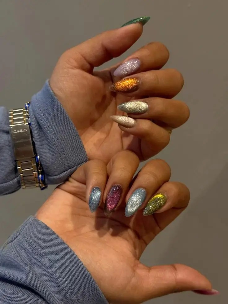 Multicolored cat eye nails featuring blue, pink, silver, gold, and green magnetic glitter.