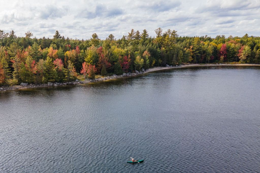 person kayaking on lake by Wild Fox Cabins