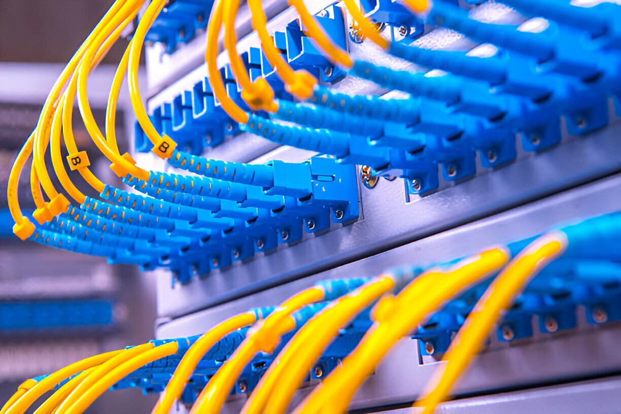 Yellow fiber optic patch cables connected to blue adapters