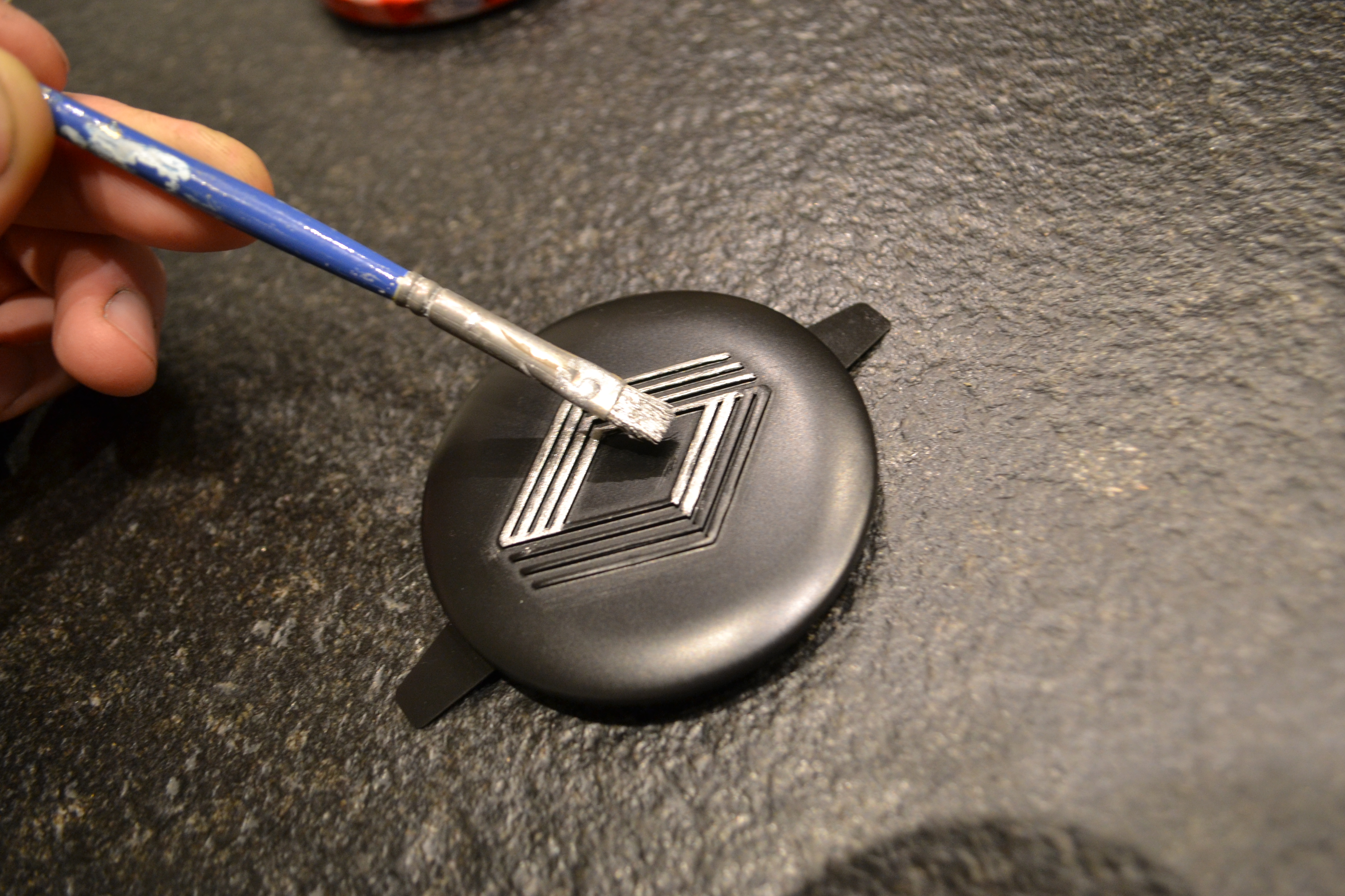 Peinture du logo Renault en gris métallisé sur le centre de roue de 4L