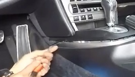 Using a trim tool to remove a vehicle center console