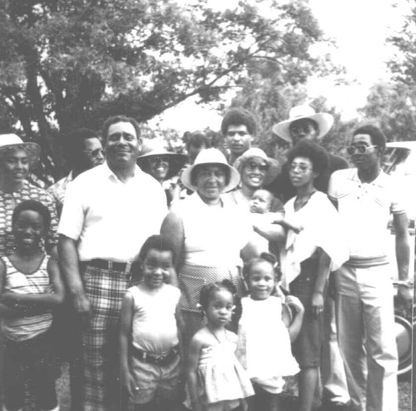 Ed Scott and his family at the Scott farm, Leflore County, Mississippi, ca. 1950s. Photograph by unknown creator. Originally published in Julian Rankin's Catfish Dream: Ed Scott's Fight for His Family Farm and Racial Justice in the Mississippi Delta (University of Georgia Press, 2018). Courtesy of Willena Scott-White. A black and white photograph depicting Ed Scott and his family smiling for the camera.