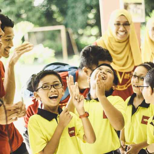 laughing children in between woman and man at daytime