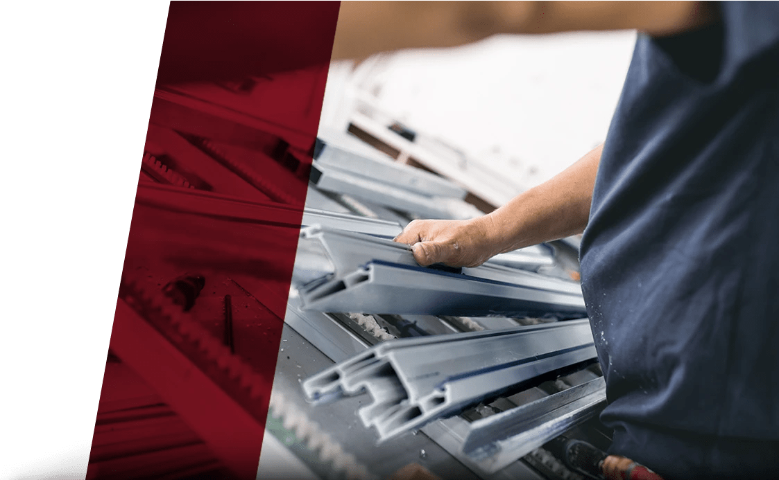 worker holding stack of aluminum extrusions