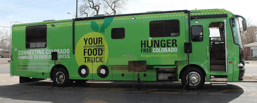 green food truck with text, showcasing motor vehicle and automotive tire details