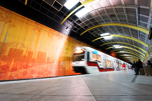 Yellow and orange train at a station, showcasing vibrant public transport colors.