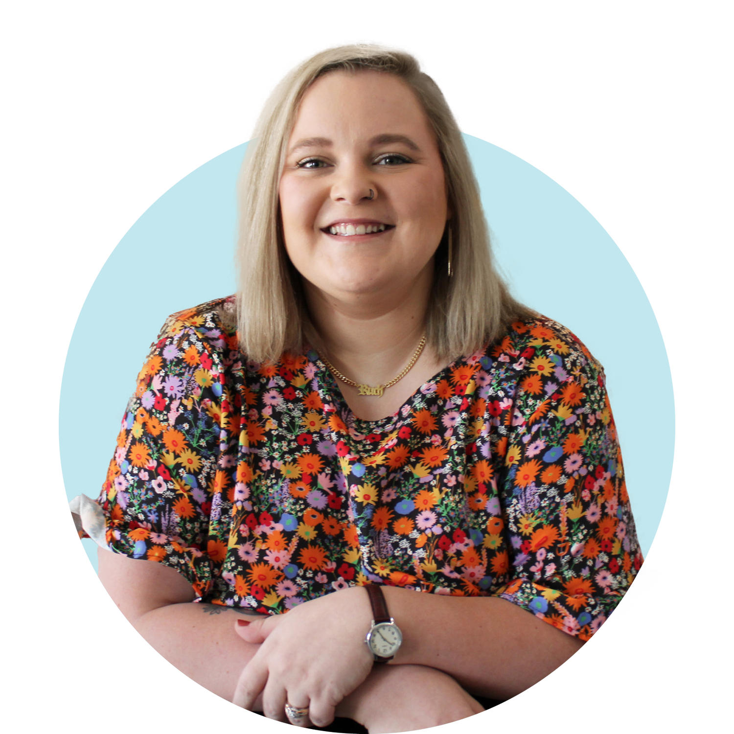 Smiling, blonde woman with shoulder length hair wearing a floral print blouse