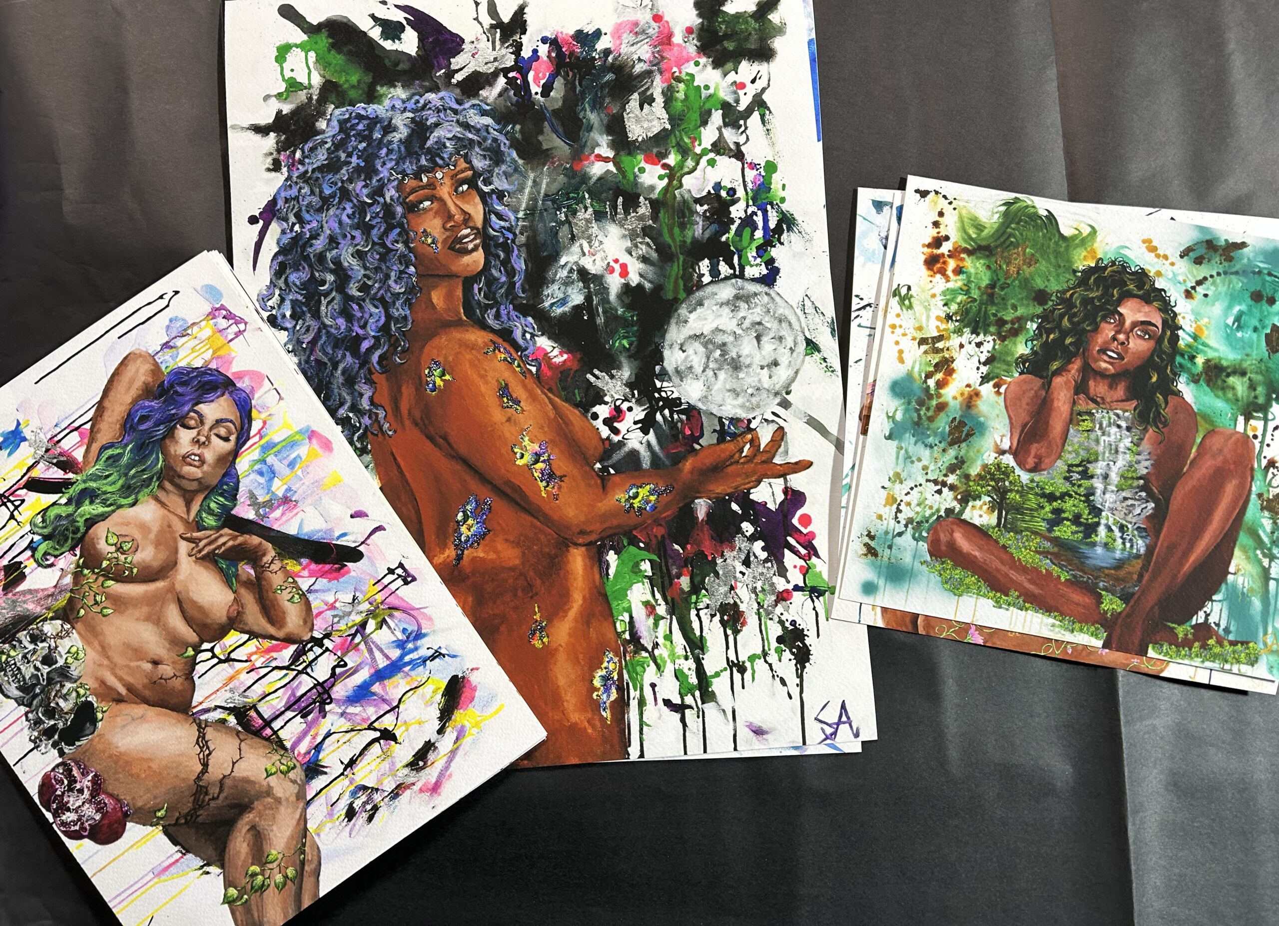 Detail of vibrant figurative paintings printed on fine art paper in an artist’s studio.