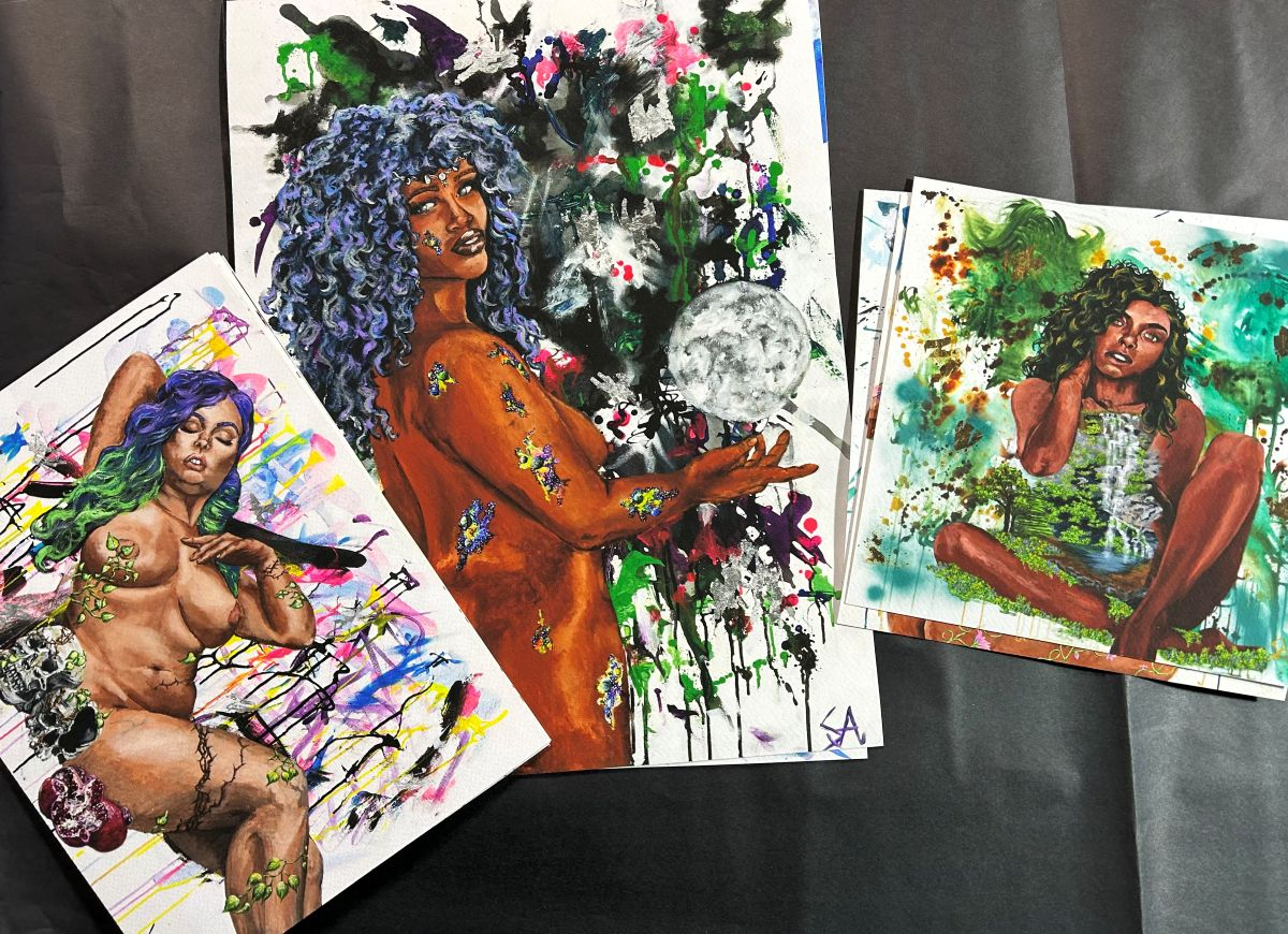 Detail of vibrant figurative paintings printed on fine art paper in an artist’s studio.