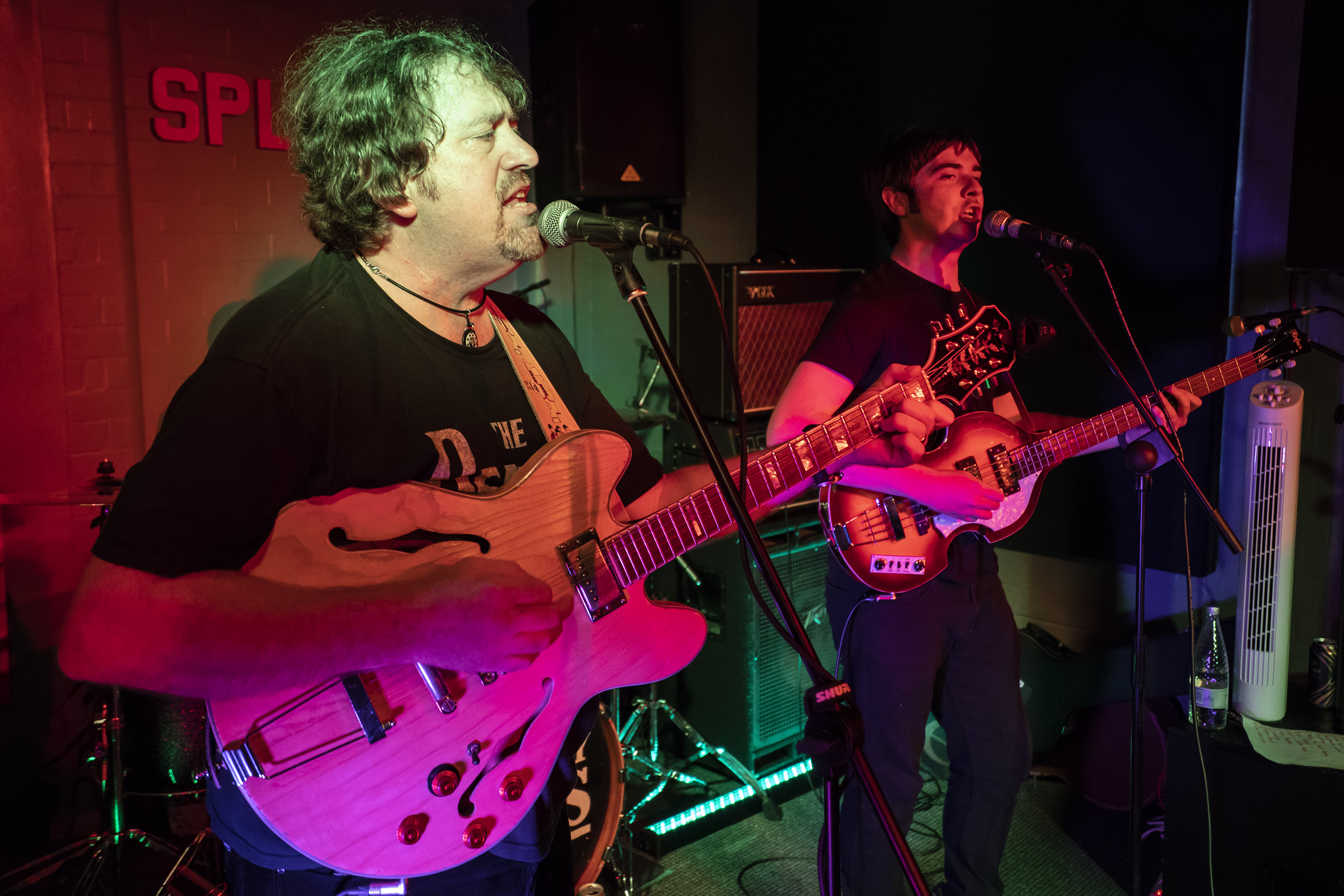 beatles tribute band playing wednesbury. both members are singing to the microphone and have a guitar and bass.