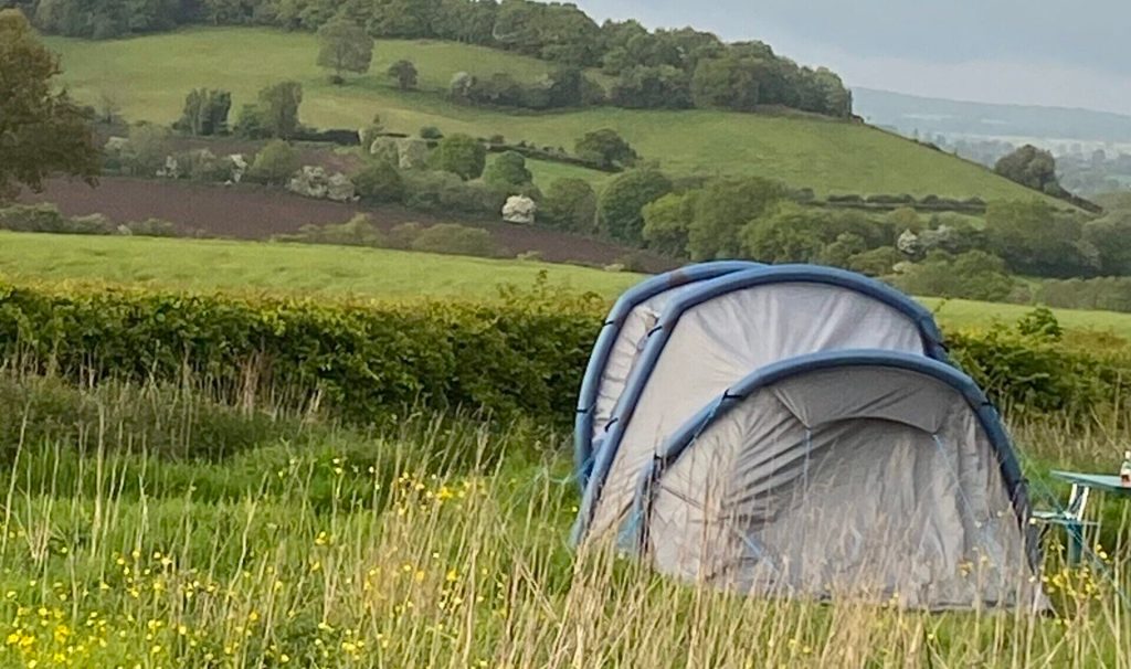 Tent in long grass overlooking the Staffordshire Moorlands