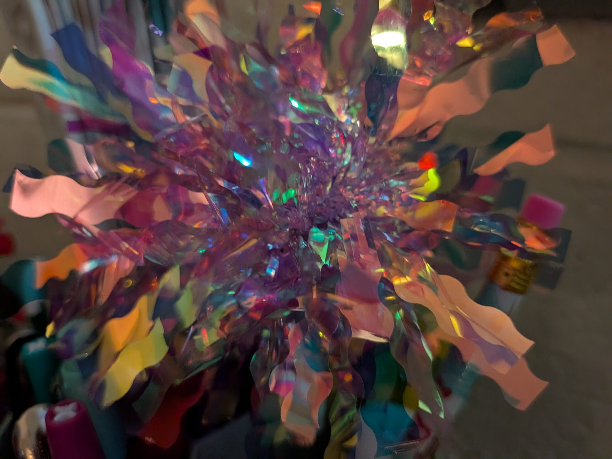 A pink and purple and yellow colored decorative poof.