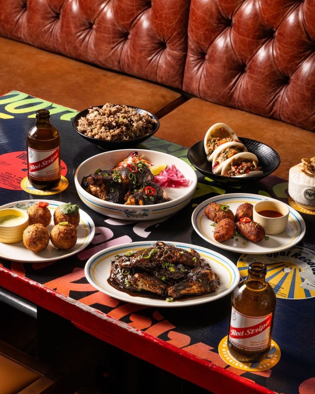 Assortment of beautifully plated dishes and small bites arranged on a dining table for An Evening at Spud's supper club in Fort Lauderdale, Florida.