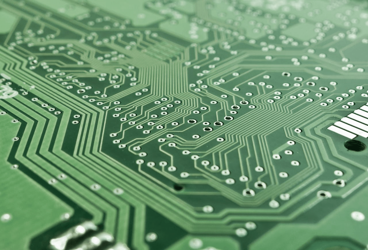Detailed view of a green circuit board with complex patterns and pathways.