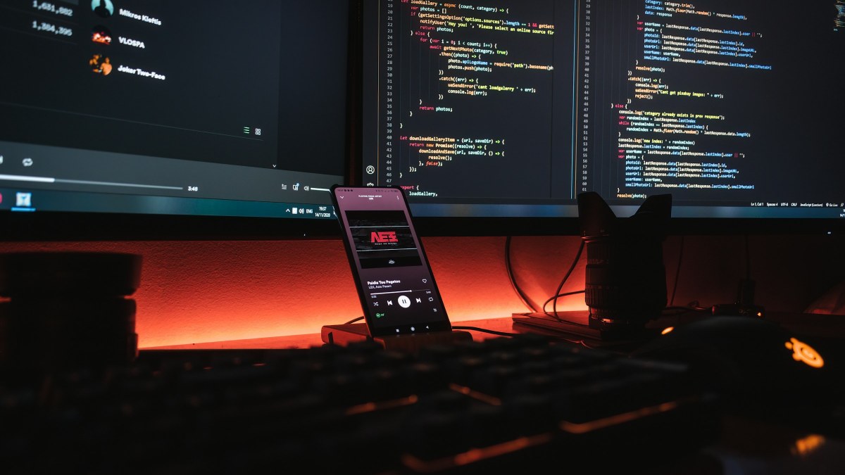 Smartphone beside computer code representing Android APK sideloading and developer verification