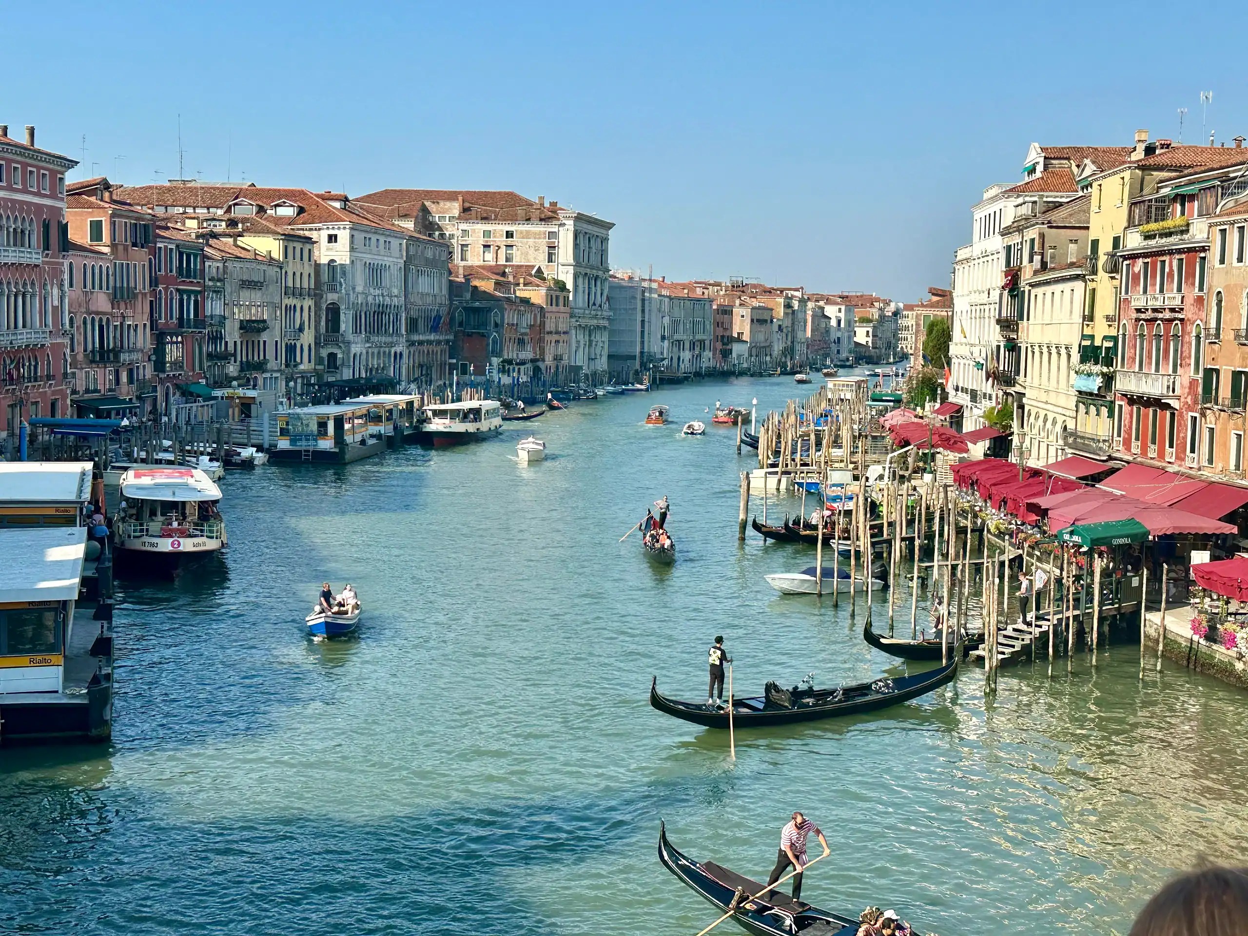 Gondolas and boats on Venice’s Grand Canal with colorful buildings, a highlight for families visiting Italy.