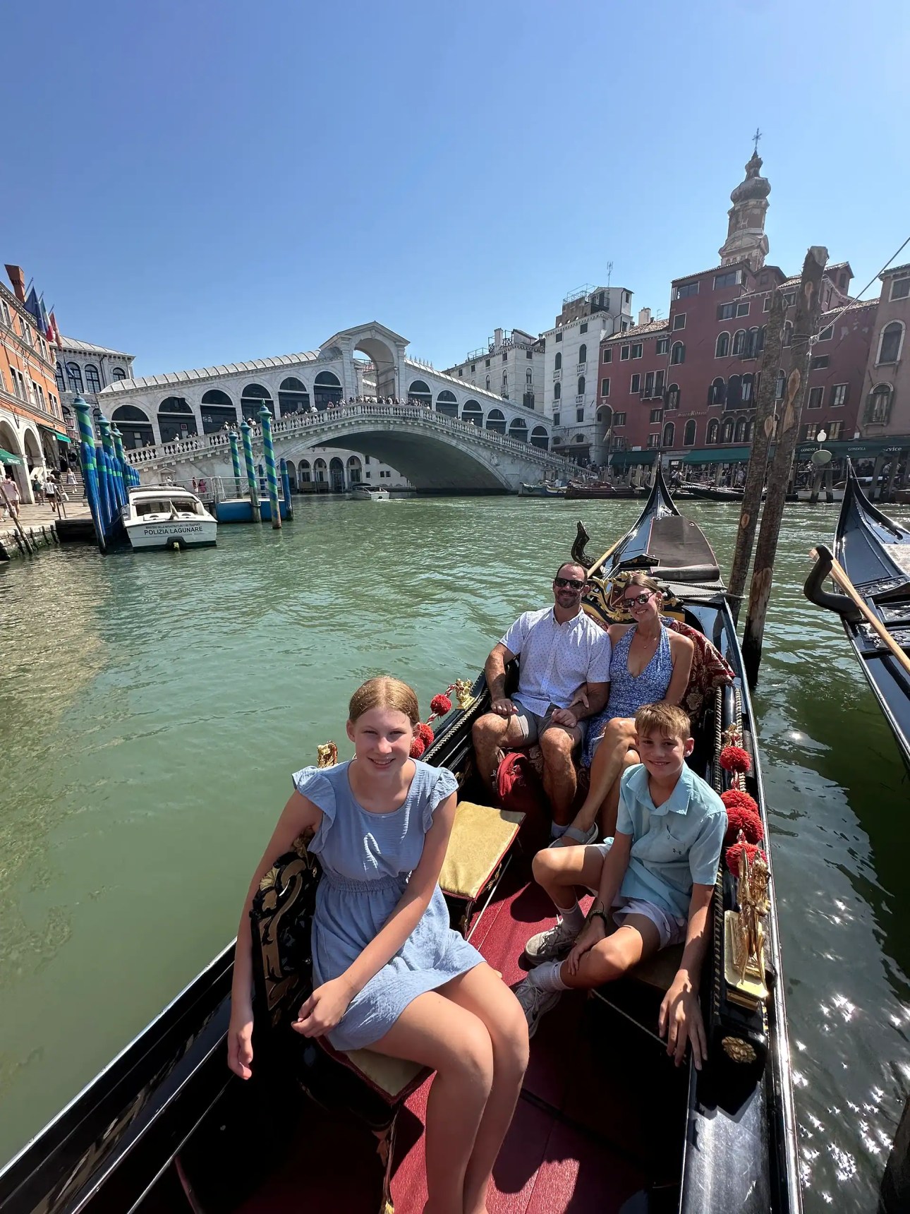 Family enjoying a gondola ride near the Rialto Bridge in Venice Italy