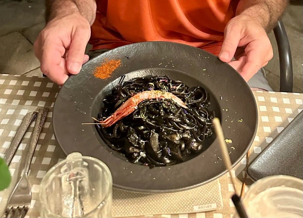 Black squid ink pasta topped with shrimp from Venice with Kids Travel Tips on local Venetian cuisine