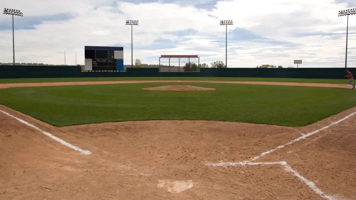 Empty baseball field viewed from home plate, representing planning a Cooperstown tournament budget