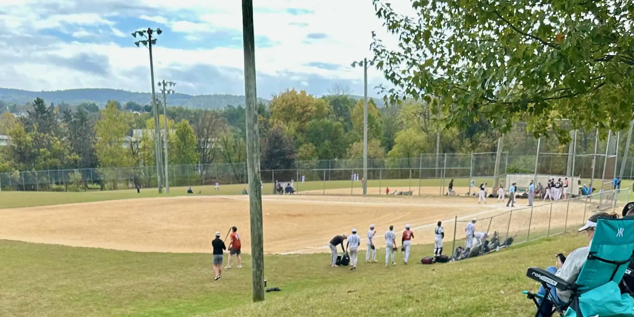 Youth baseball tournament field on a warm summer day, showing long hours at the ballpark and limited shade