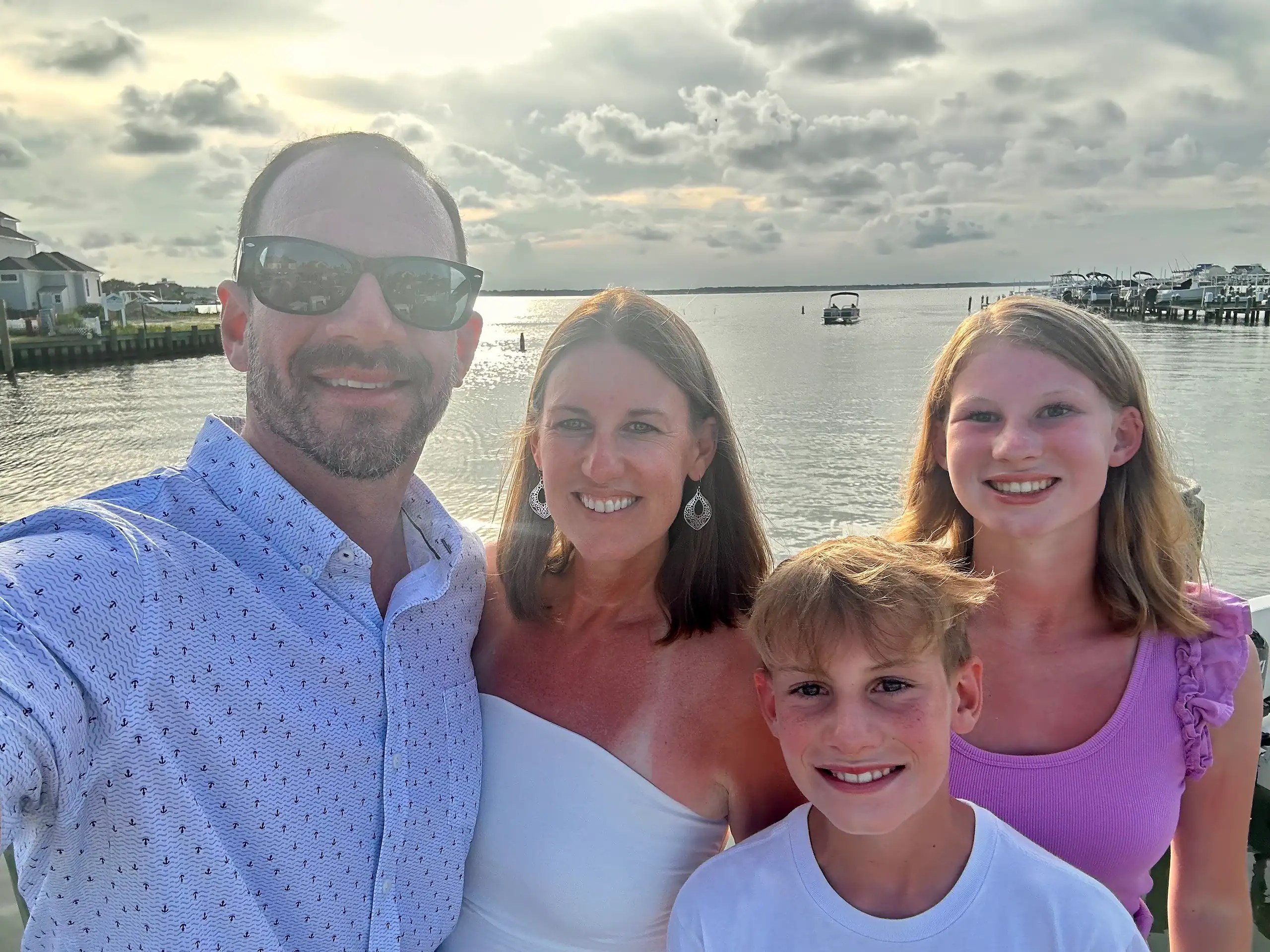 Family standing together near the water, showing where we spend and save on family trips