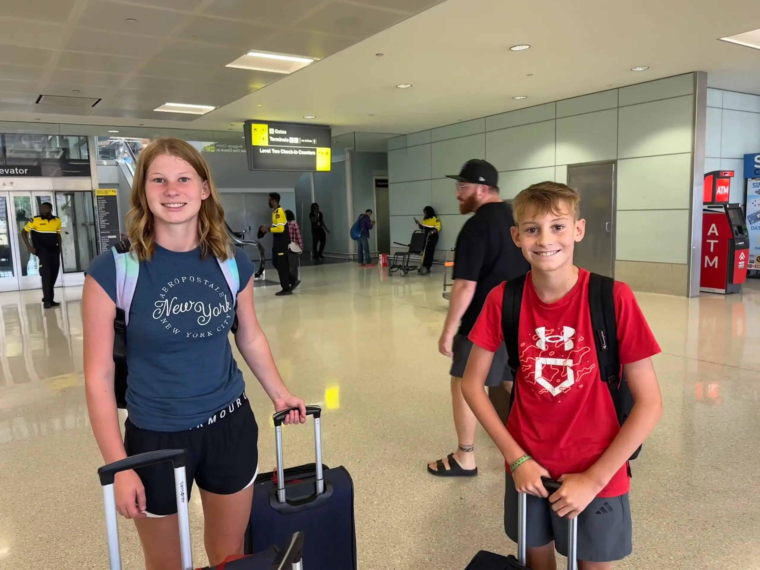Family at airport with rolling suitcases before international flight, representing smart travel tips and travel planning
