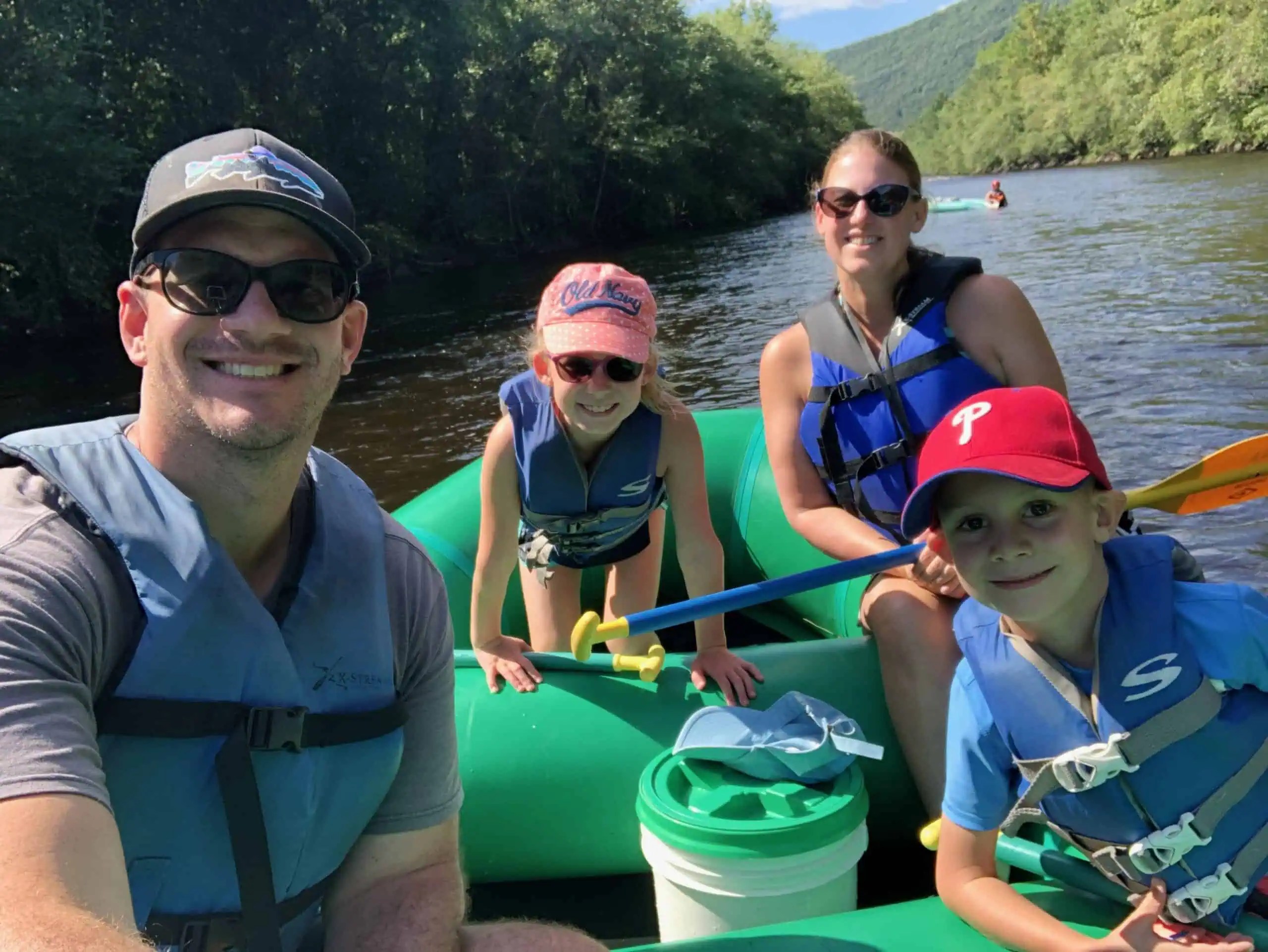Family enjoying whitewater rafting in the Poconos with kids on the Lehigh River in Pennsylvania.