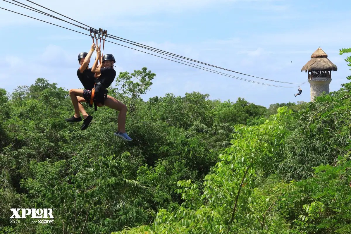 Brother and sister zip-lining together above the trees at Xplor
