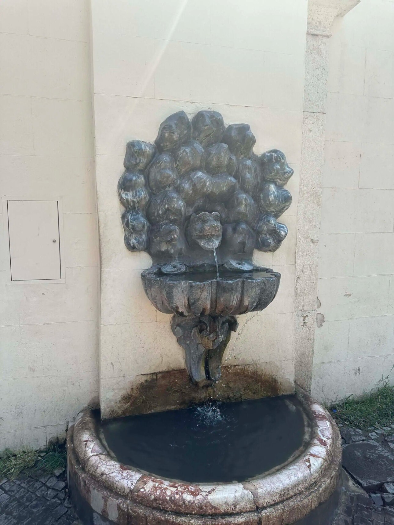 Public drinking water fountain in Rome used to refill water bottles while sightseeing