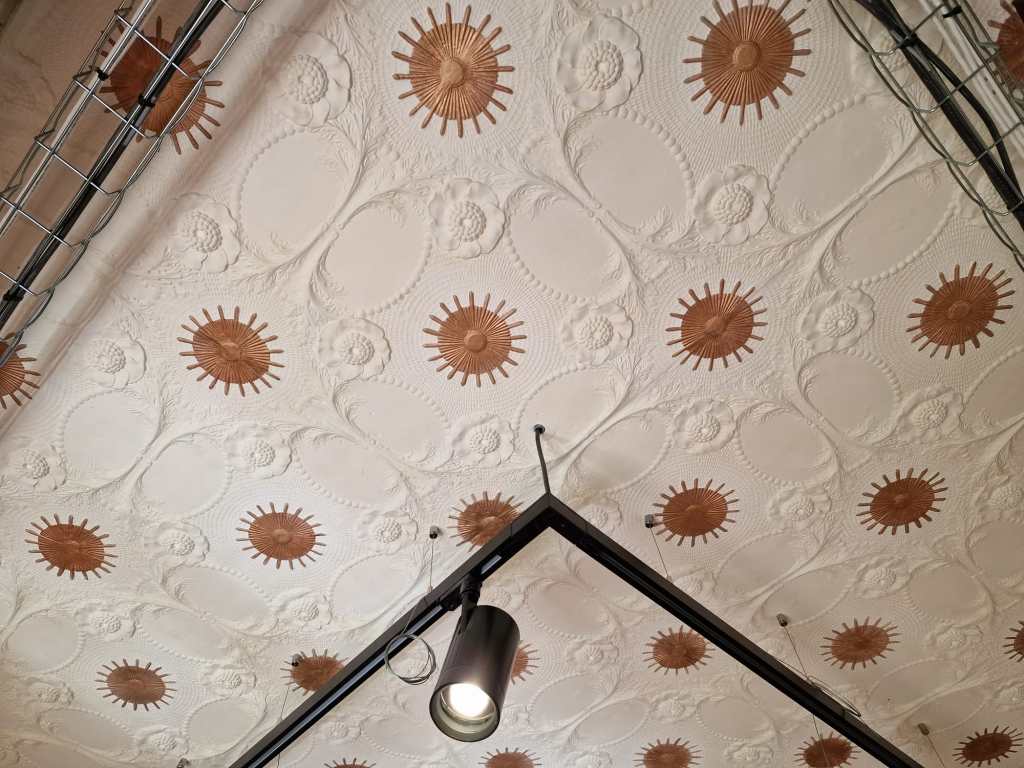 Plafond à rosaces dorées et entrelacs blancs après restitution