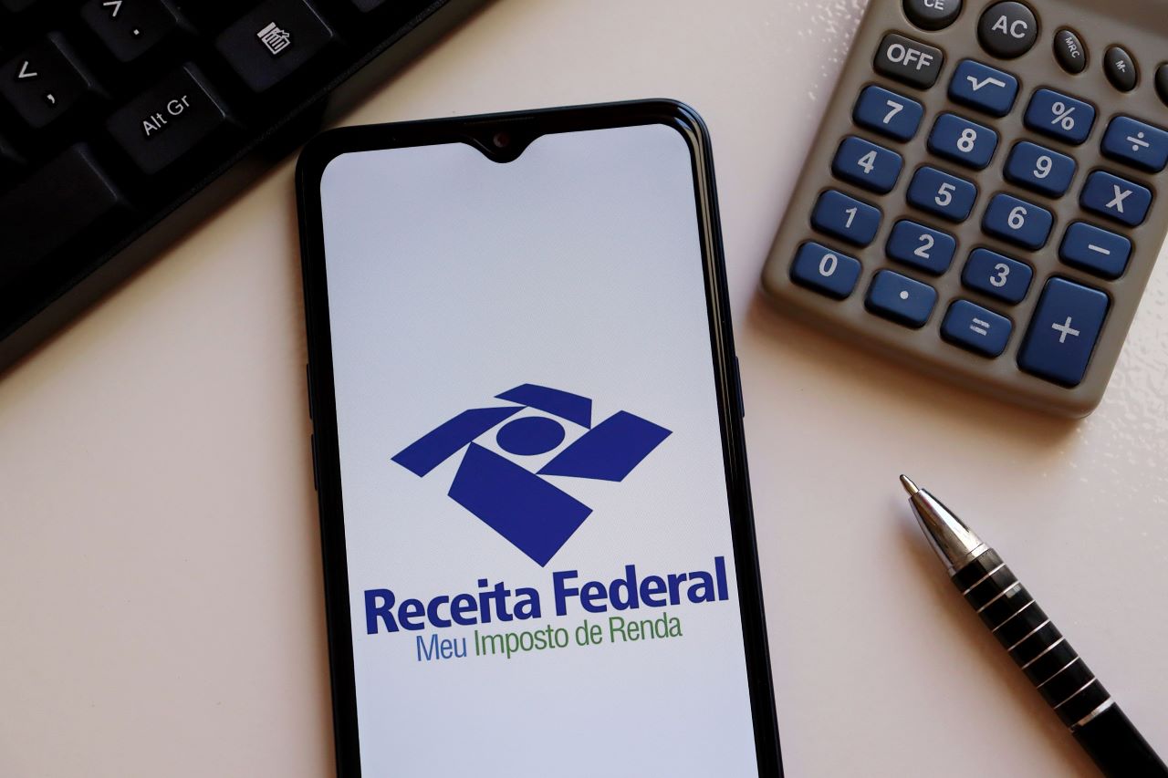 Quem precisa declarar Imposto de Renda​? | Foto de um celular no app da Receita Federal, uma calculadora, uma caneta e o teclado de um notebook | Certificação Digital | Blog da Certisign