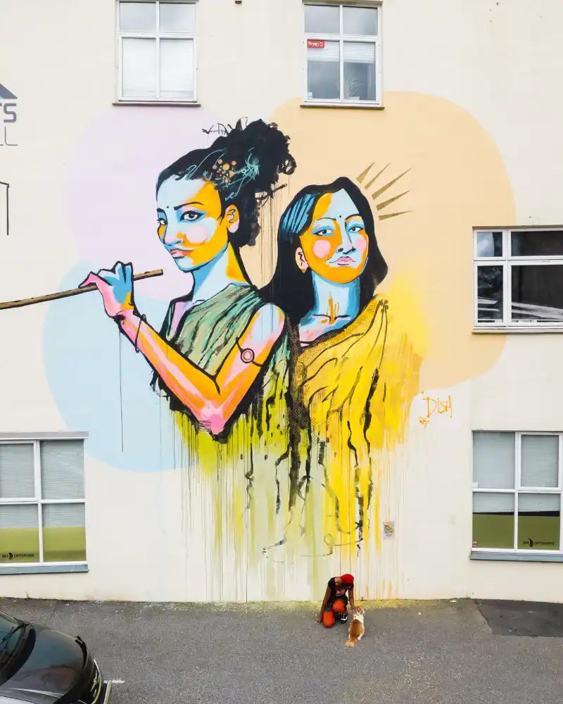 Painted wall with two women and the artist.