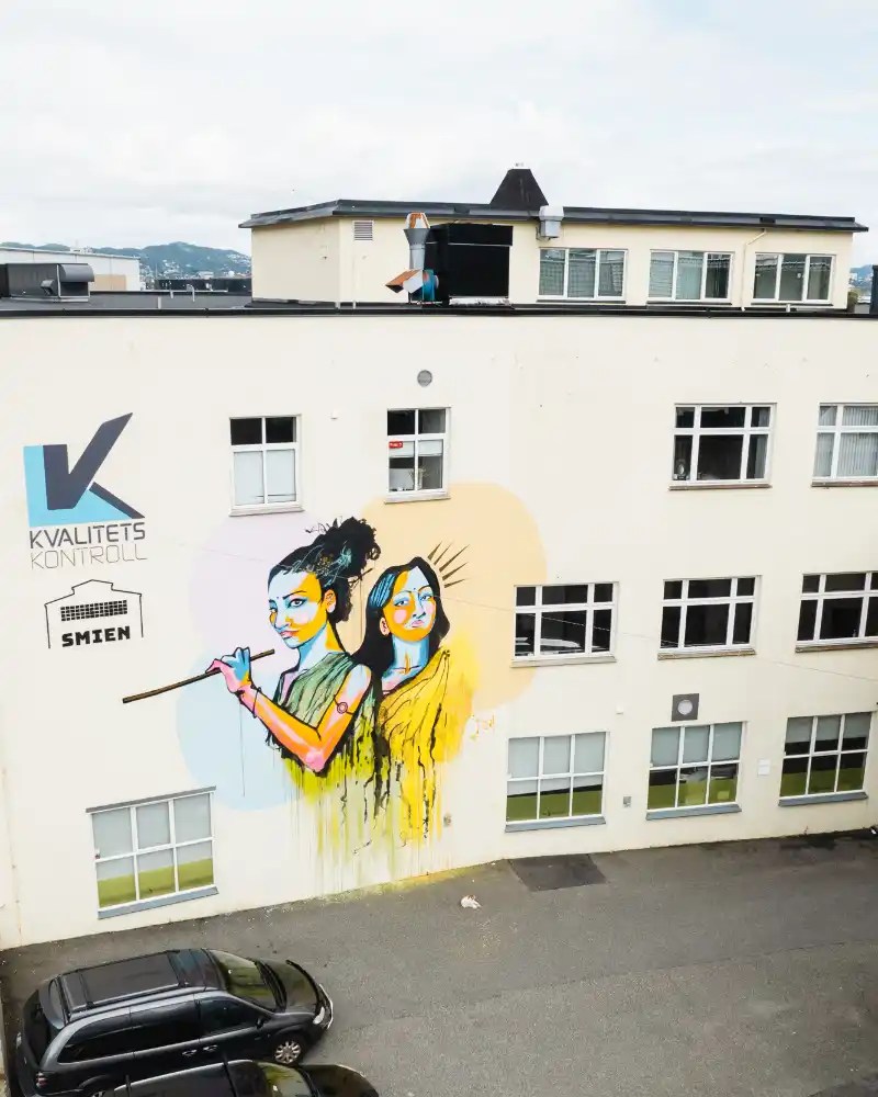 Painted wall with two women from a distance.
