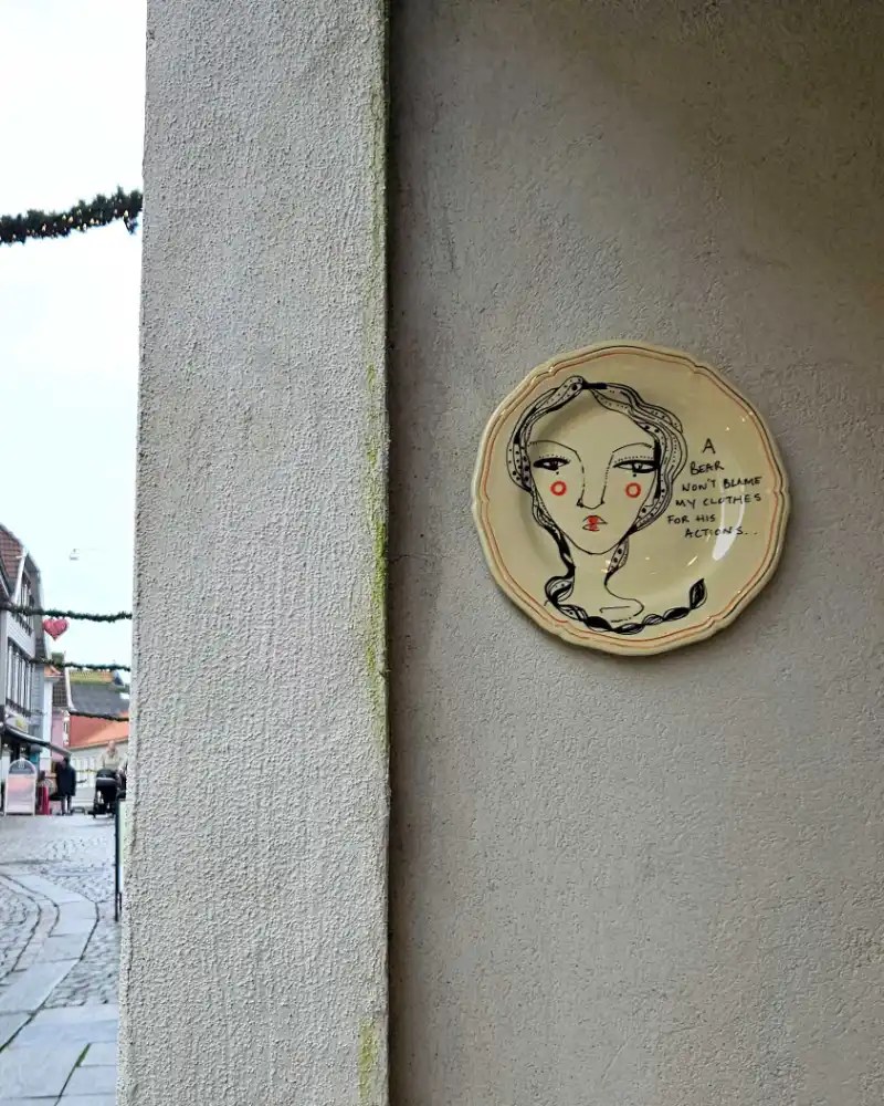 Hand-painted ceramic dish with a woman and text.
