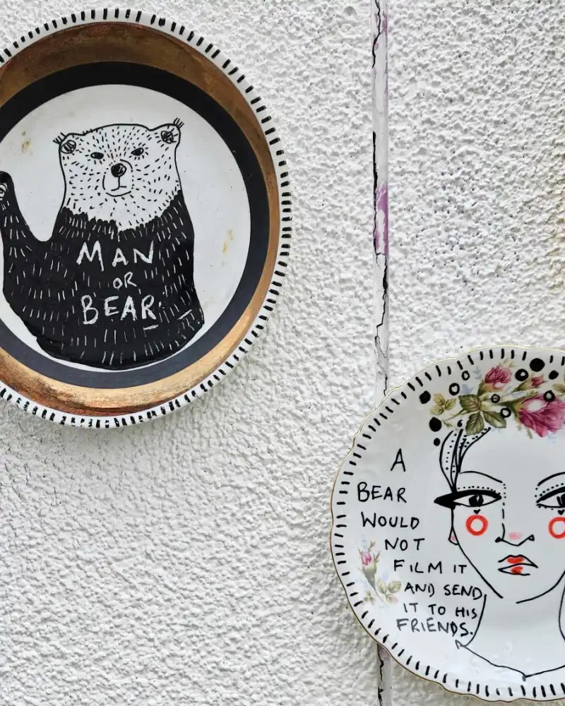 Hand-painted ceramic dish with a woman and a bear.