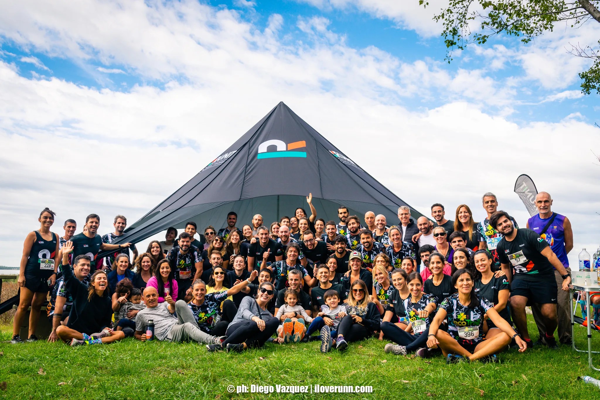 Foto grupal de corredores con una carpa de fondo