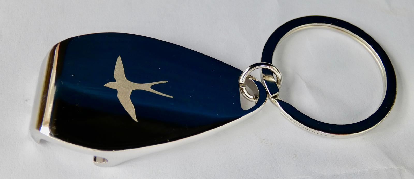 Image depicts swallow logo on metal bottle opener keyring.