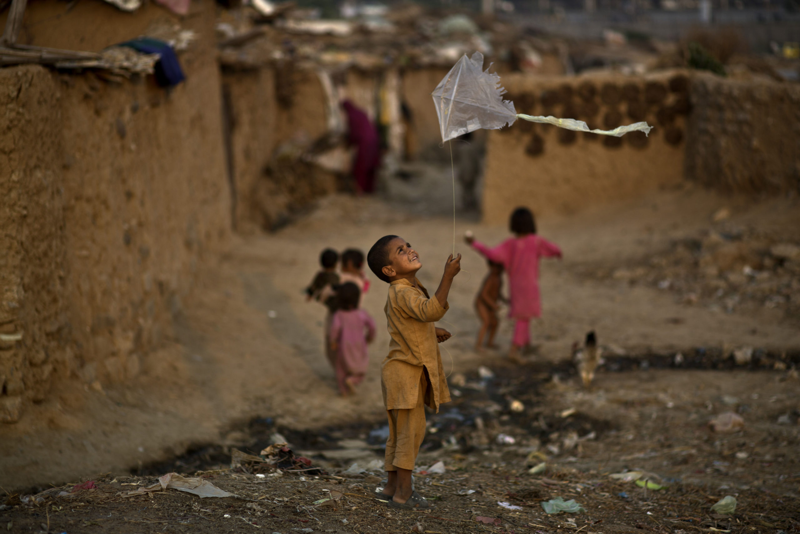 An Afghan refugee boy plays with a kite in a poor neighborhood on the outskirts of Islamabad, Pakistan.