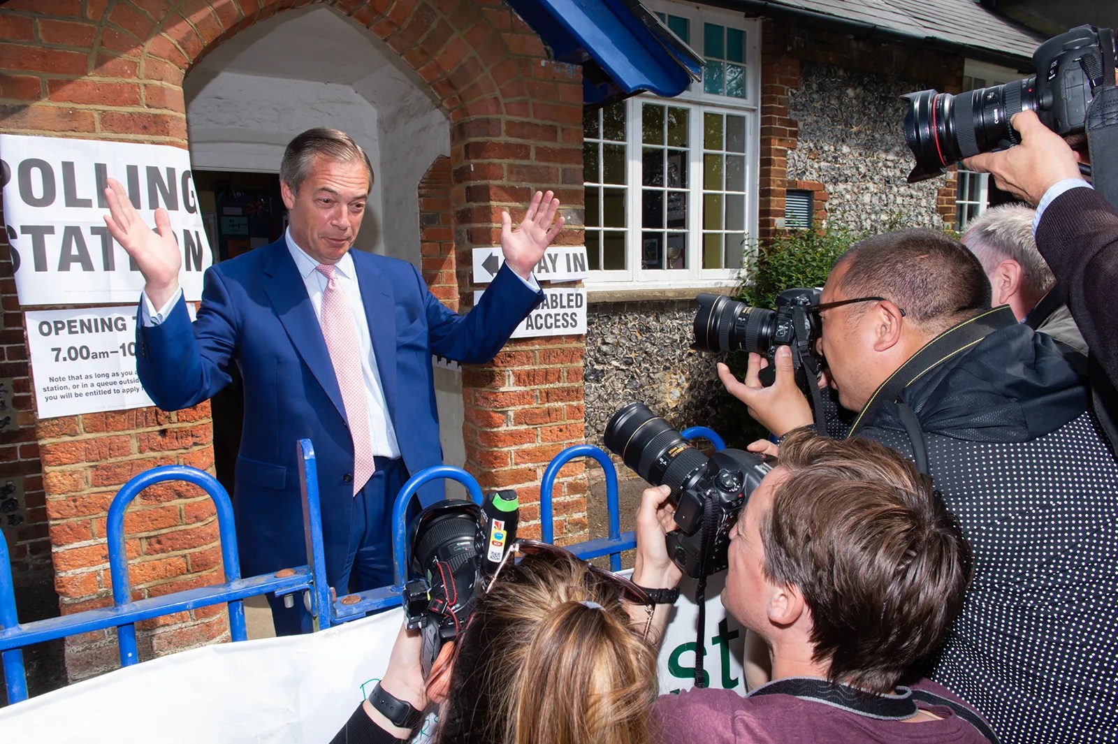 Nigel Farage poses for the cameras outside of a polling station.