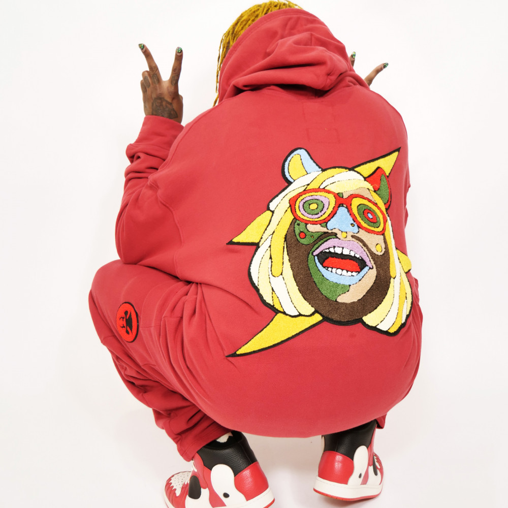 Thundercat posing crouched down showing the peace sign.