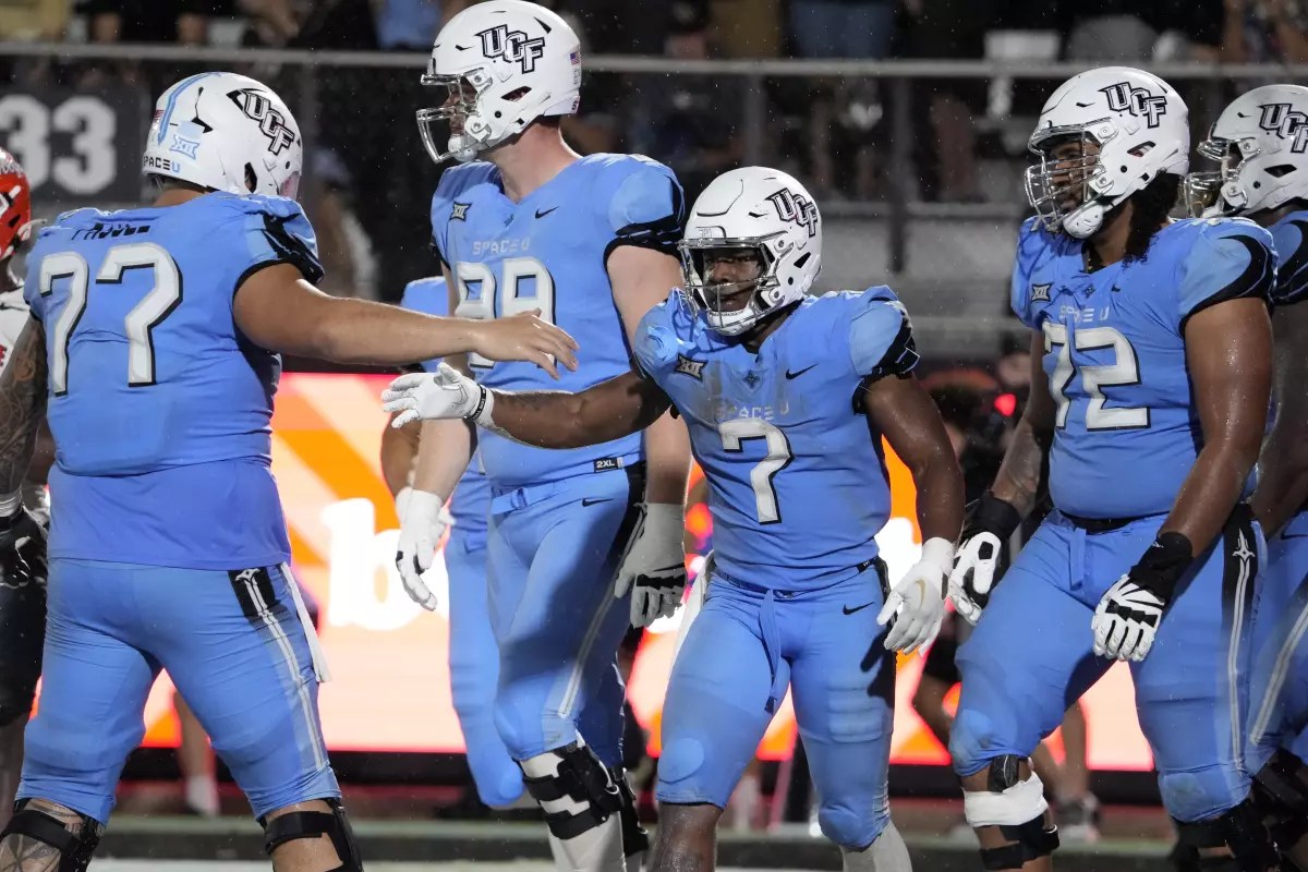 Central Florida running back RJ Harvey (7) celebrates his 2-yard touchdown run against Oklahoma State with teammates including offensive lineman Lokahi Pauole, and offensive lineman Marcellus Marshall (72) during the second half of an NCAA college football game, Saturday, Nov. 11, 2023, in Orlando, Fla. (AP Photo/John Raoux) (John Raoux / Associated Press)