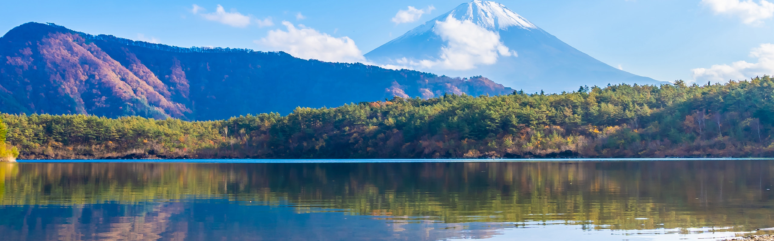 Still lake surrounded by trees and hills, reflecting a sense of peace and personal reflection