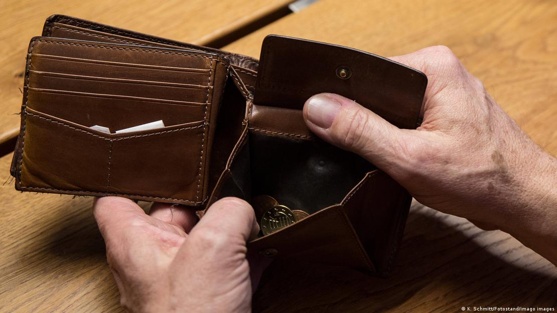 Foto de archivo de una persona que revisa dinero en su cartera. Foto de archivo de una persona que revisa dinero en su cartera.