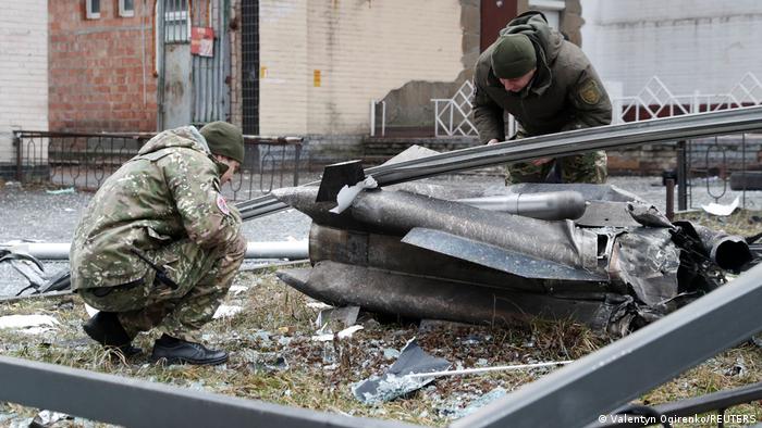 Ukrainian police inspect the remains of a missile on a street Ukrainian police inspect the remains of a missile on a street