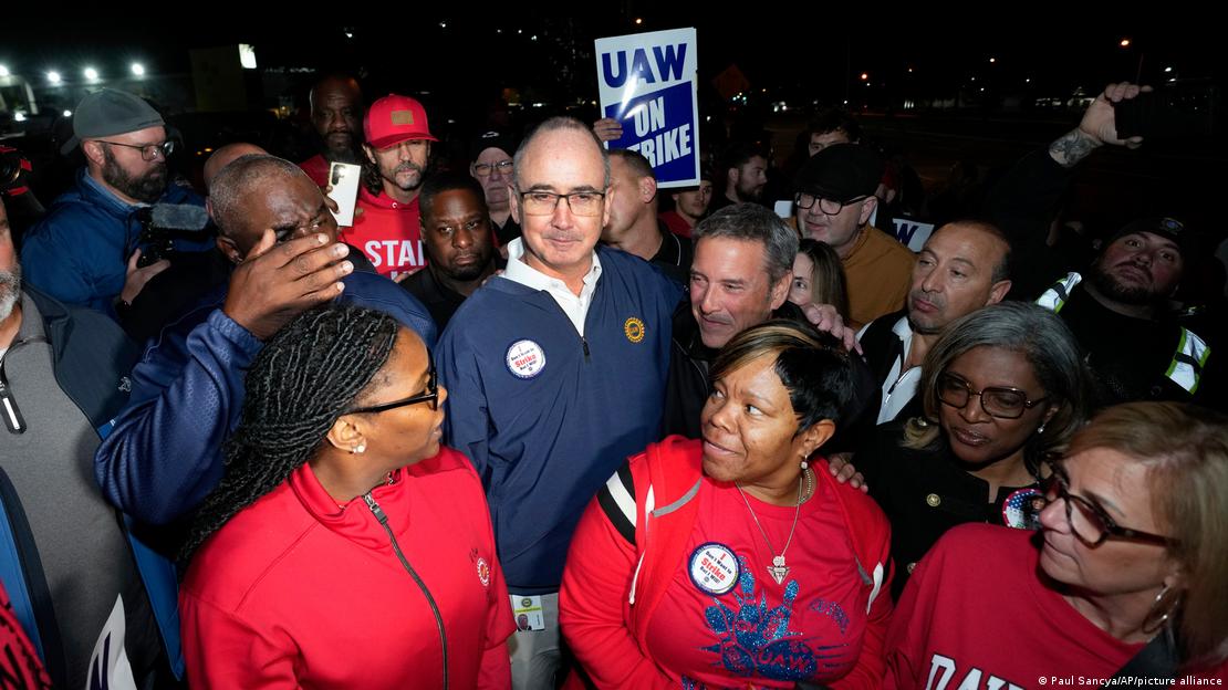 El presidente de la United Auto Workers, Shawn Fain, al centro, junto a los miembros del UAW en huelga en la planta de ensamblaje de Ford en Wayne, Michigan.